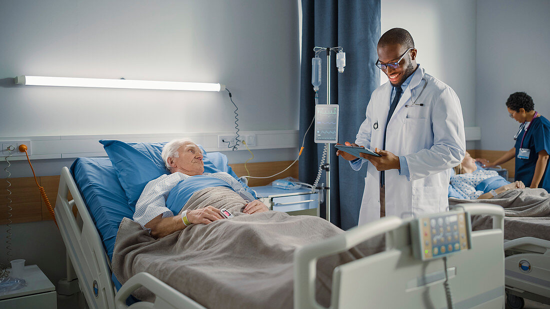 Doctor talking with elderly patient on hospital ward