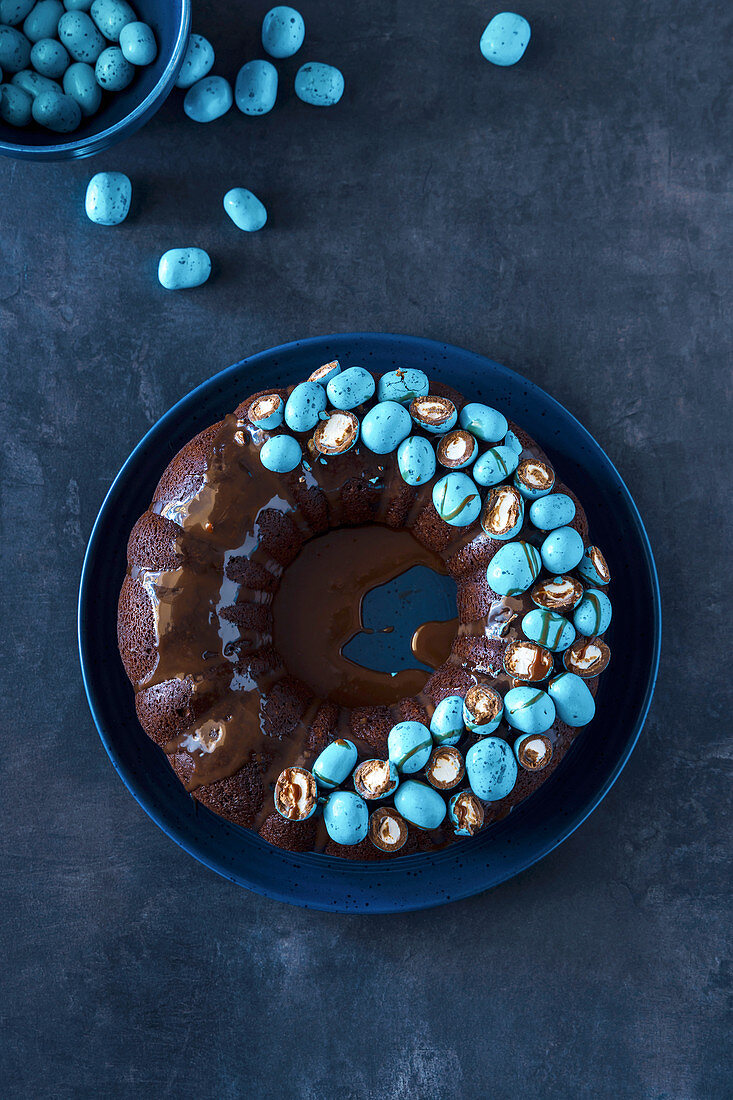 Easter Dark Chocolate Bundt Cake Decorated with Turquois Blue Milk Chocolate Eggs with Marshmallow Center