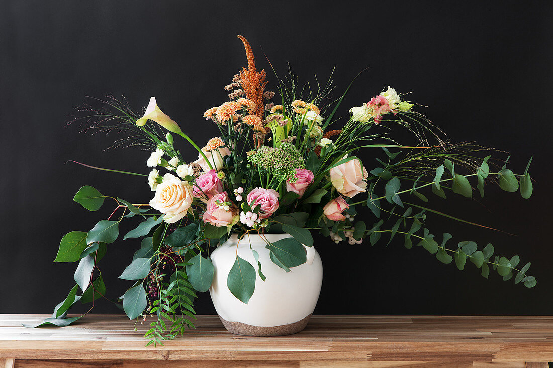 Bouquet of roses, eucalyptus, chrysanthemums, amaranth, carnations, pink pepper, calla lilies and grasses