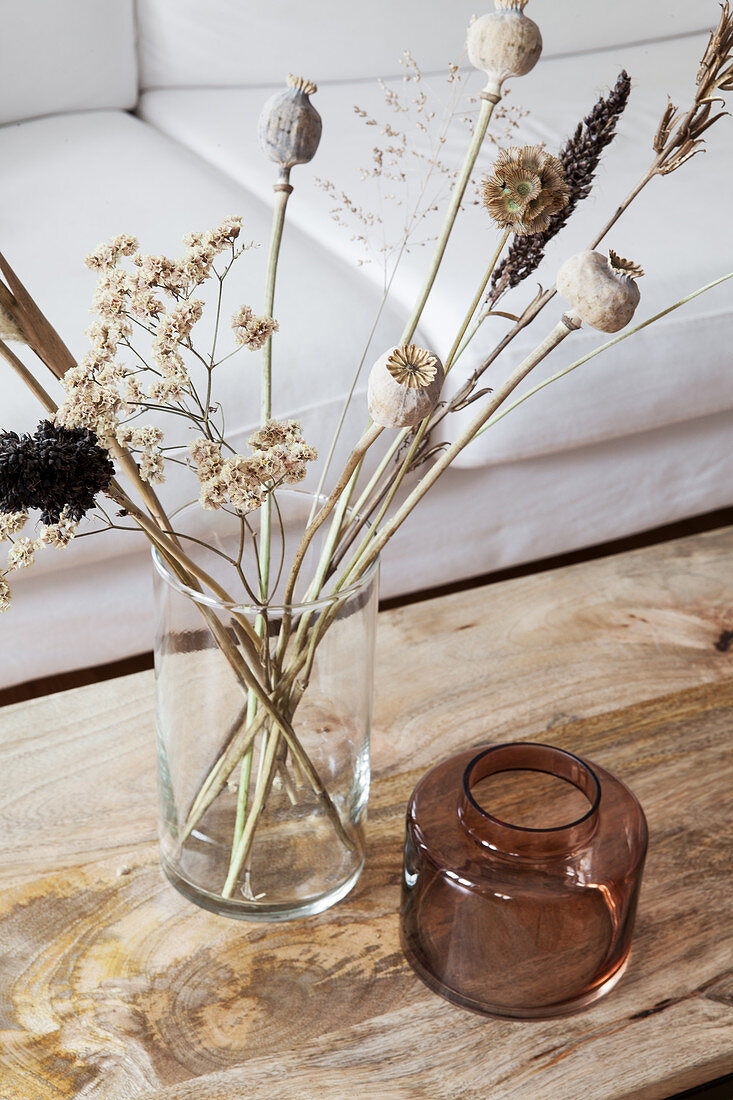 Strauß aus Trockenblumen auf Couchtisch mit Holzplatte