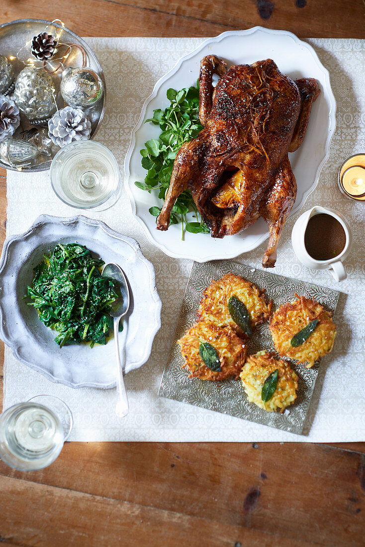 Orange-stuffed Christmas duck and potato rösti cakes with sage leaves