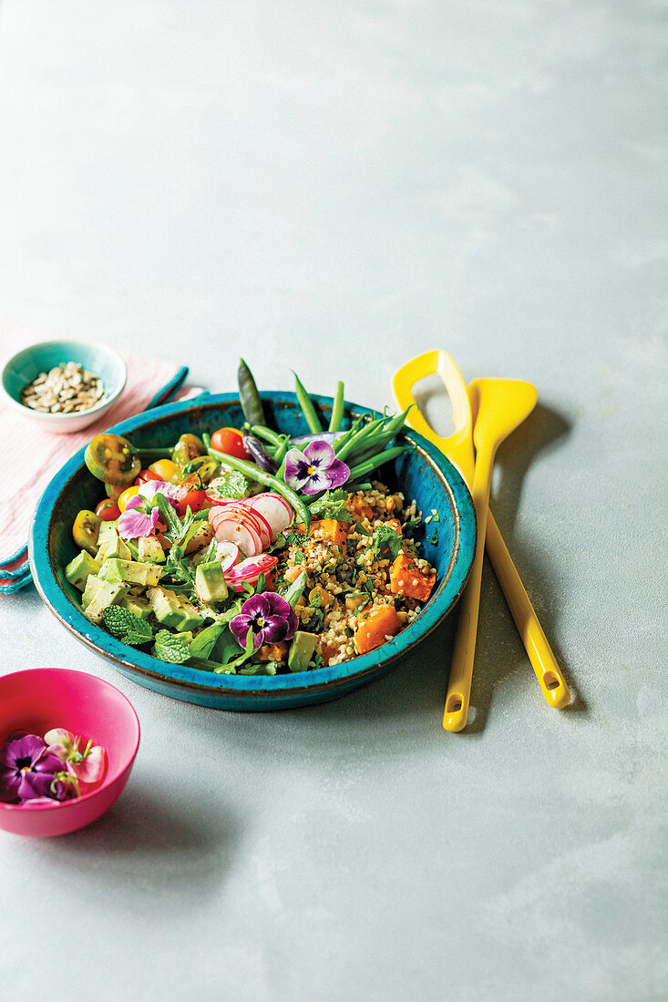 Getreide-Bowl mit Kräutern, Avocado, Bohnen und Radieschen