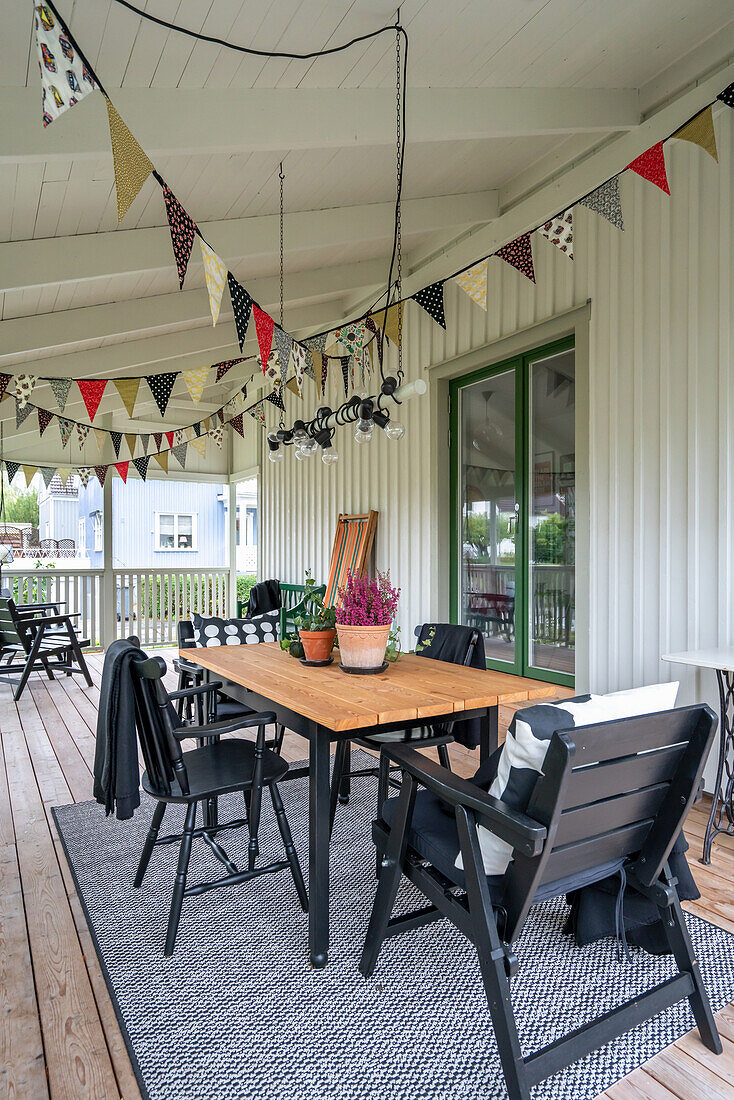 Strings of bunting above dining table on covered veranda