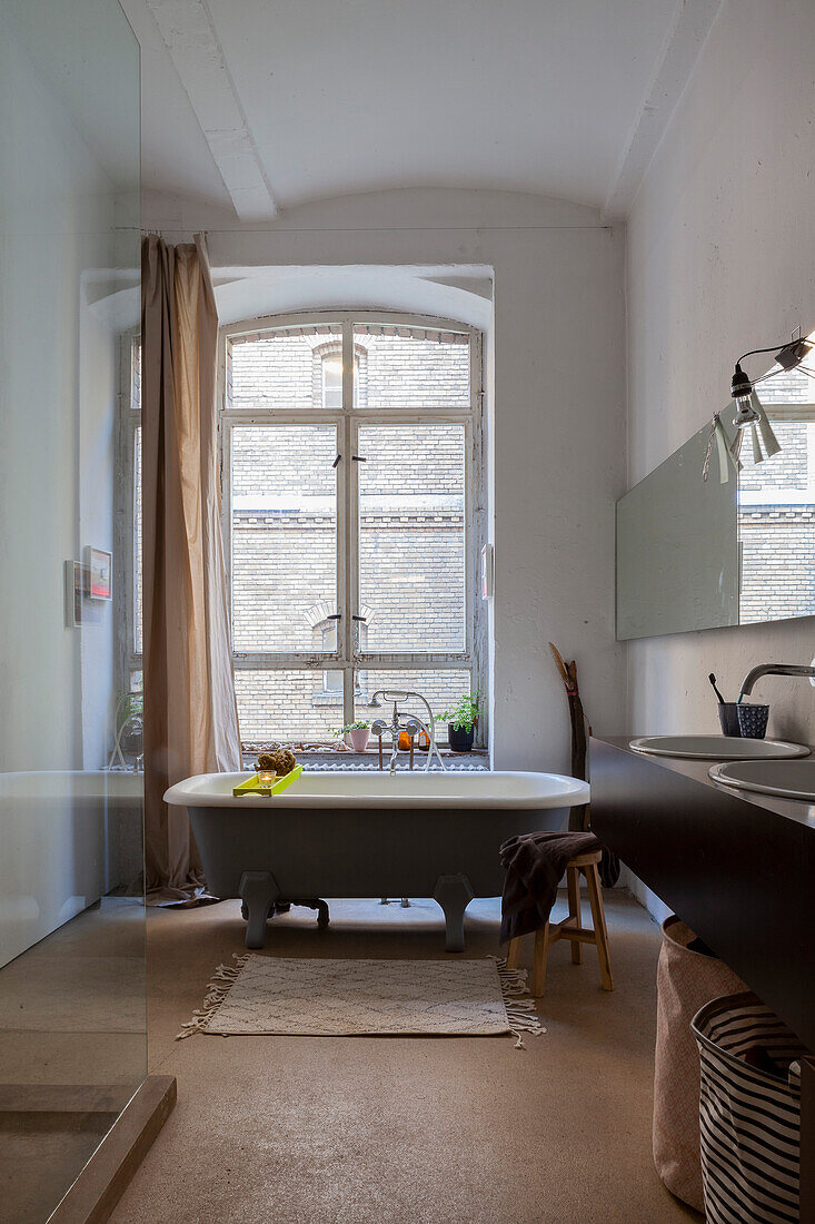 Freestanding bathtub in bathroom in an old building with a vaulted ceiling