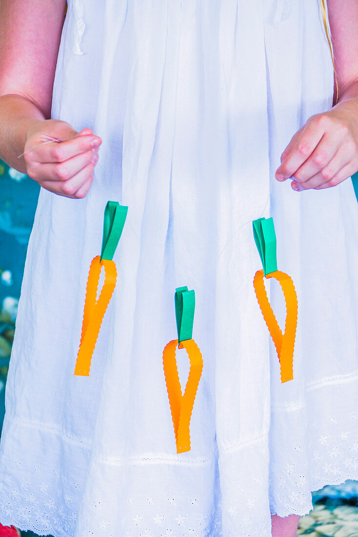 Paper carrot garland held by girl
