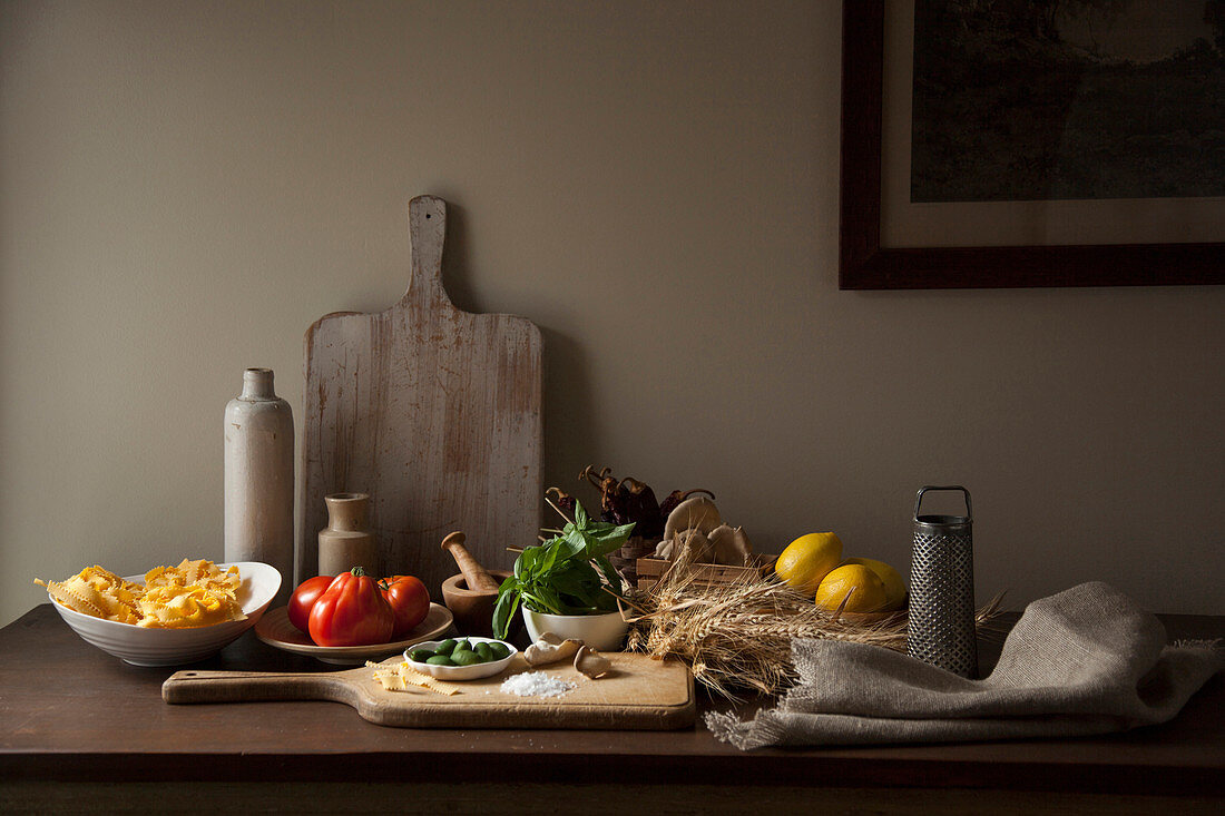 Italienische Zutaten auf Tisch mit Holzschneidebrett in rustikalem Ambiente