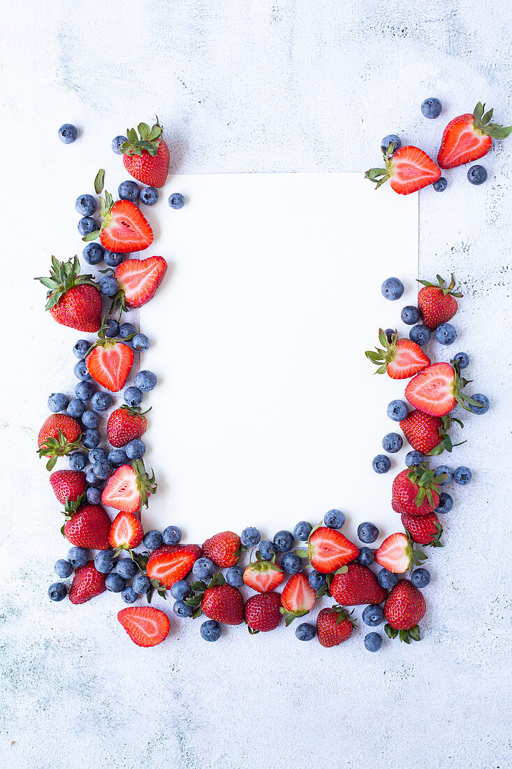 Erdbeeren und Blaubeeren als Rahmen gelegt