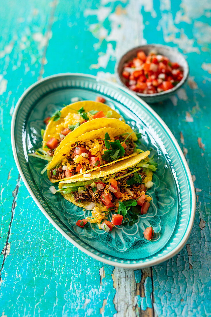 Taco shells with ground beef, salsa and cheddar