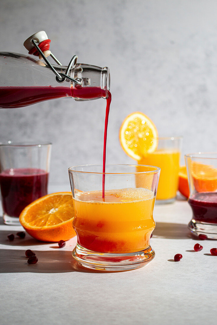 Pomegranate juice being poured into orange juice