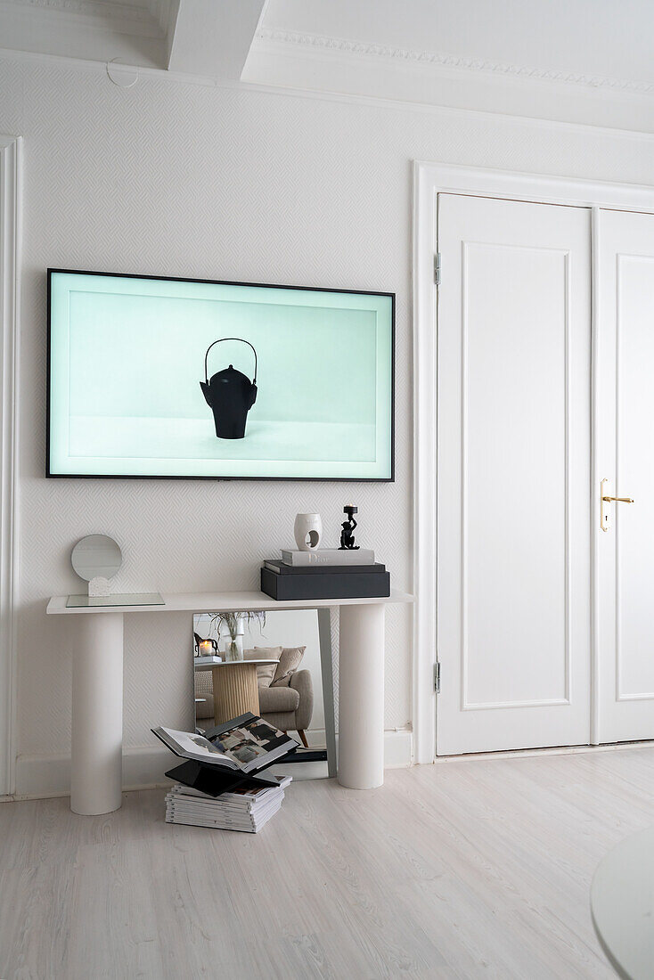 Modern art above a console table next to double door in room