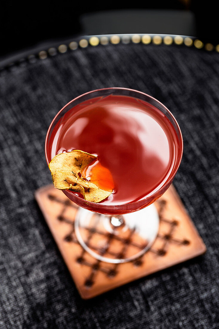 Rotes Cocktail mit getrockneter Apfelscheibe