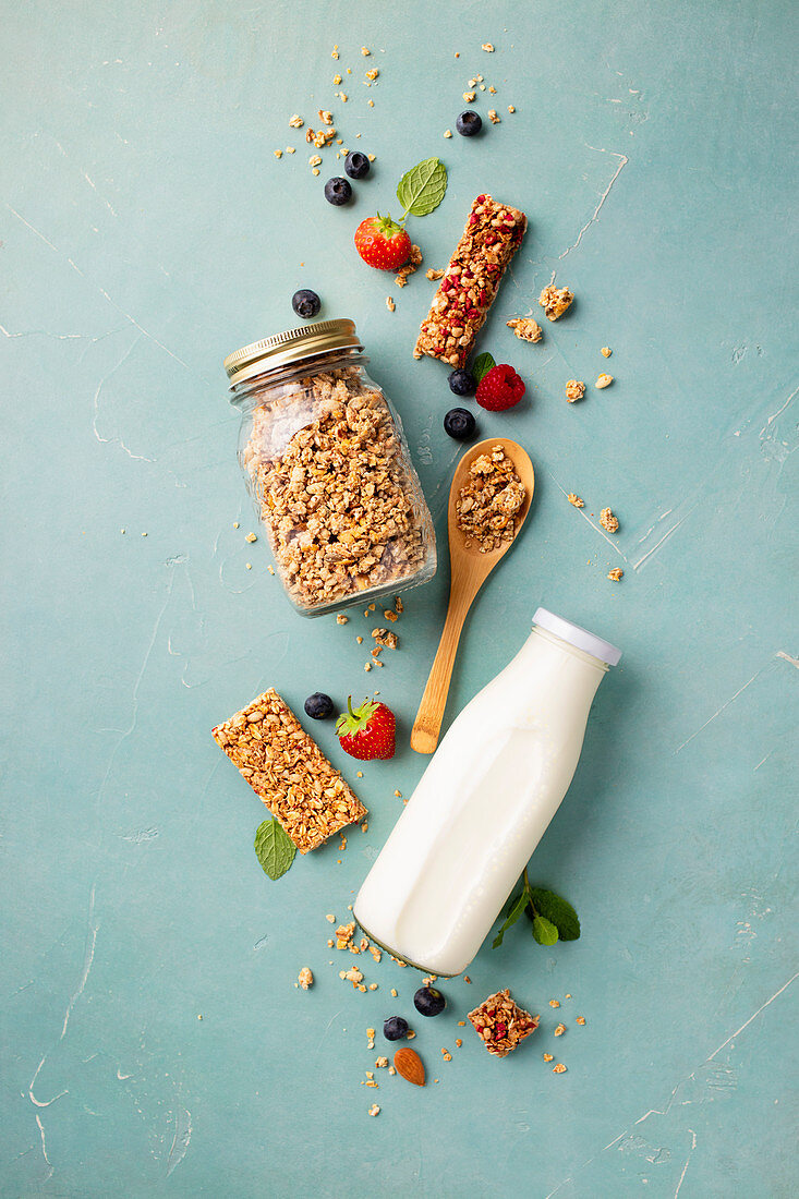 Homemade granola in a glass jar with milk and berries