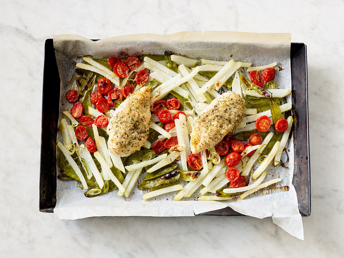 Chicken with a herb crust on a baking tray