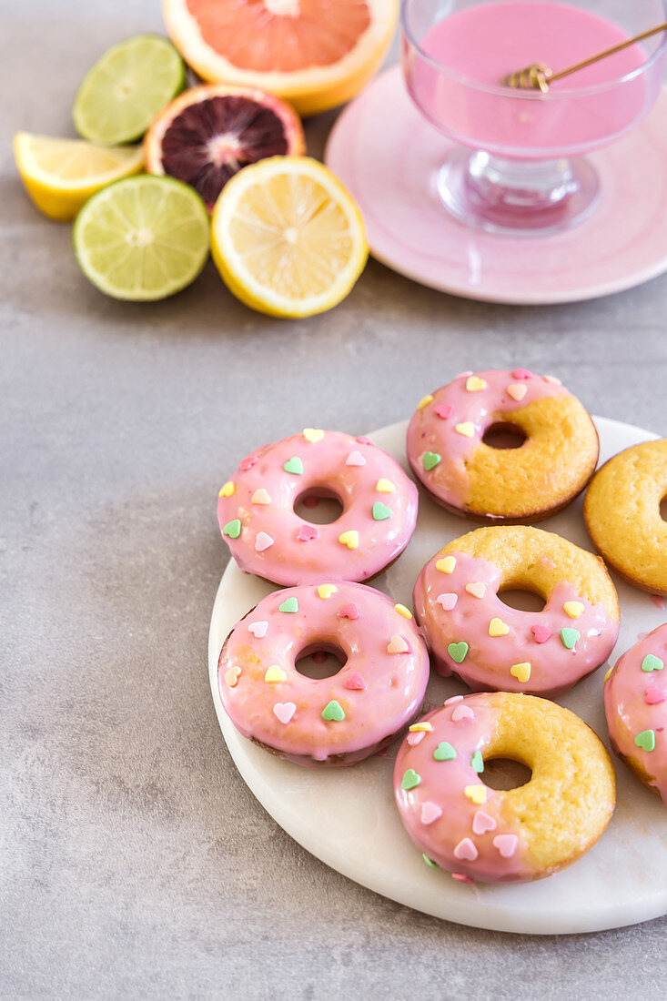 Mandel-Donuts mit Blutorangenglasur und herzförmigen Zuckerstreuseln