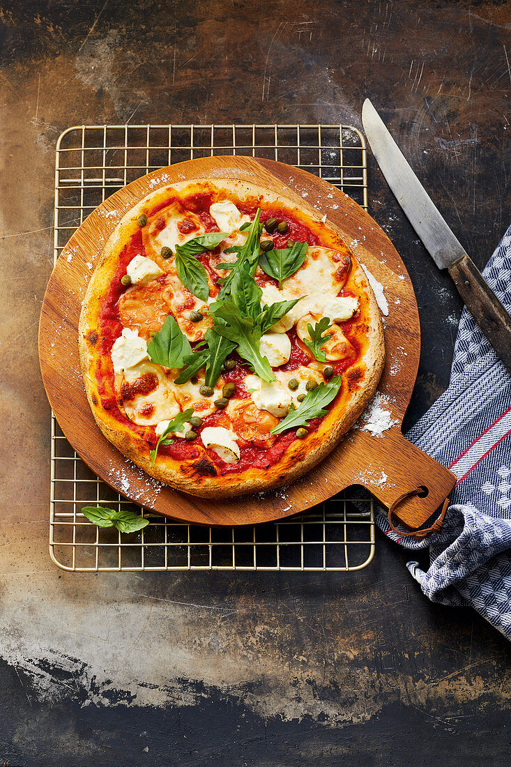 Pizza with three kinds of cheese, capers and rocket