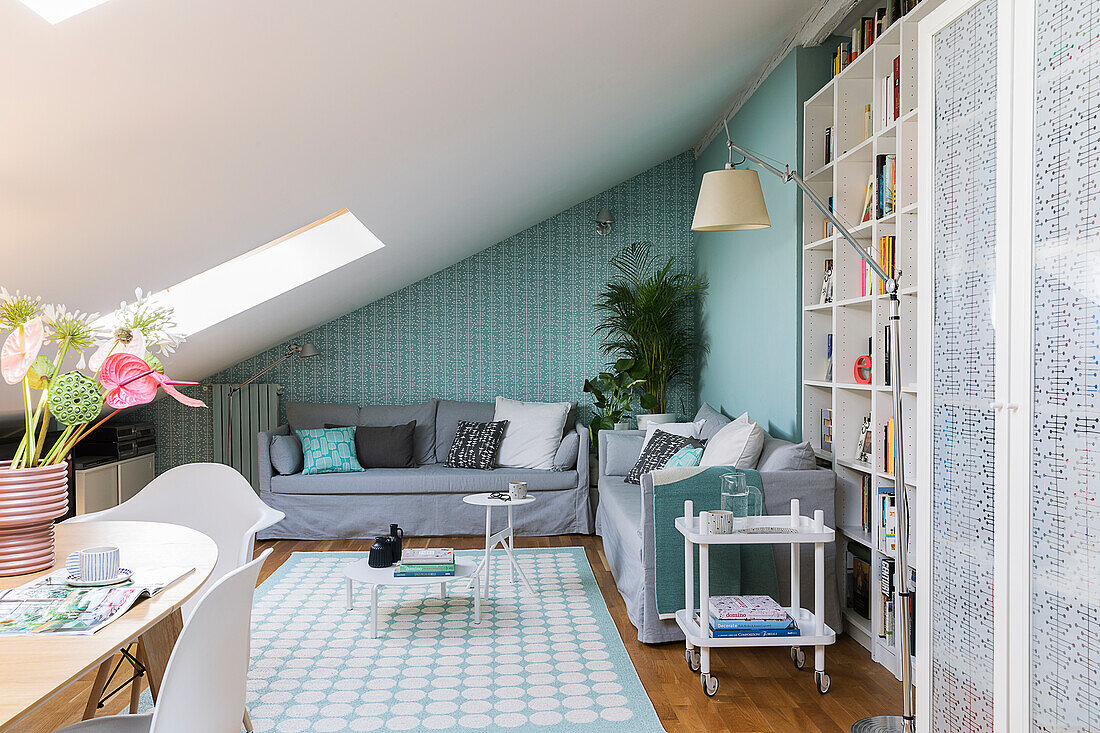 Open living room with dining table and seating area in an attic apartment