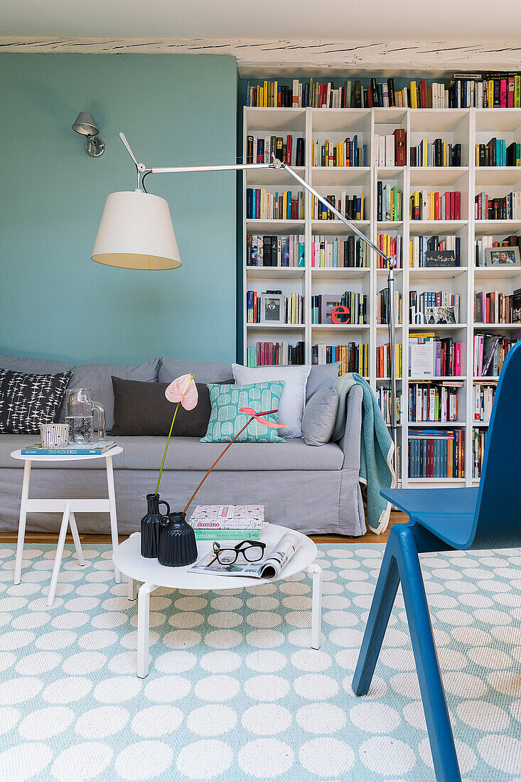 Coffee table, couch with cushions and bookcase in a living room