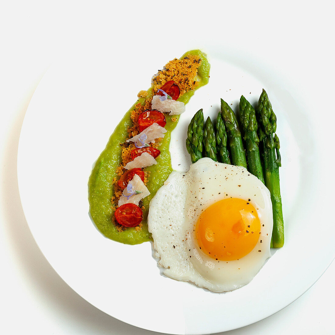 Green asparagus with fried egg, asparagus cream and confit tomatoes
