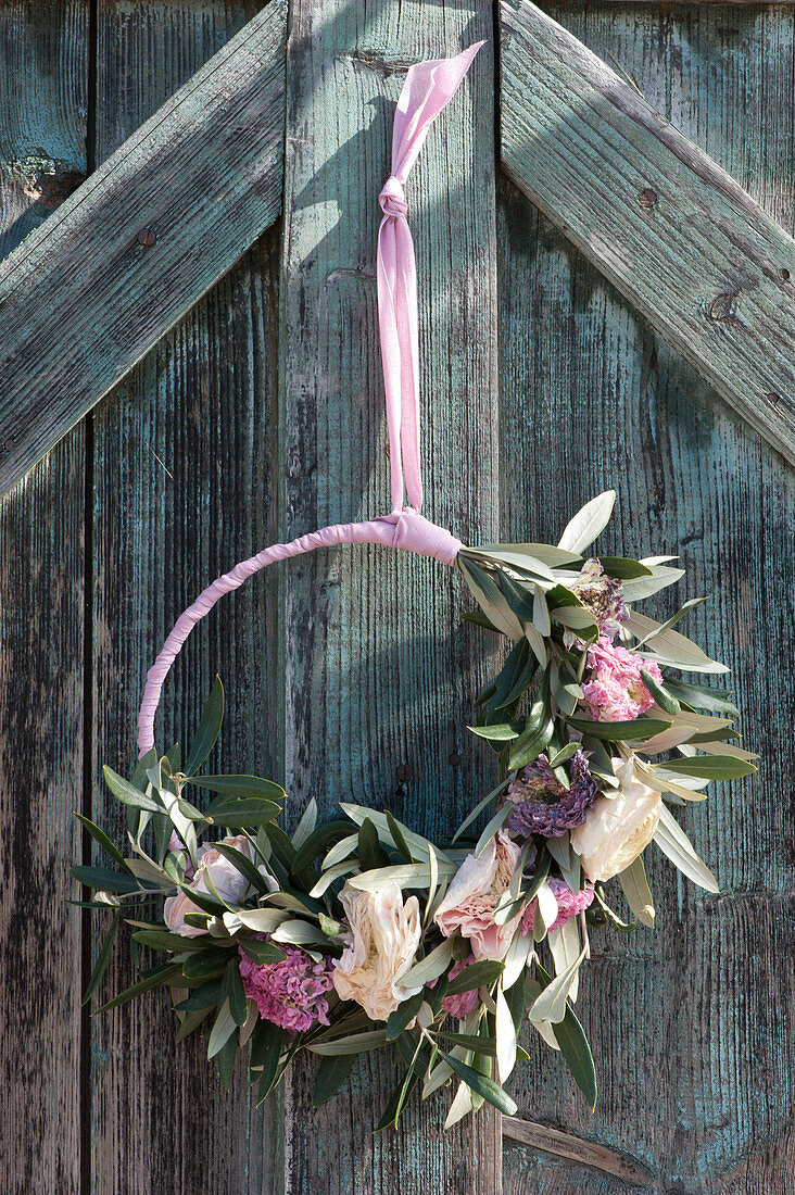 Door wreath with ranunculus blossoms and olive branches