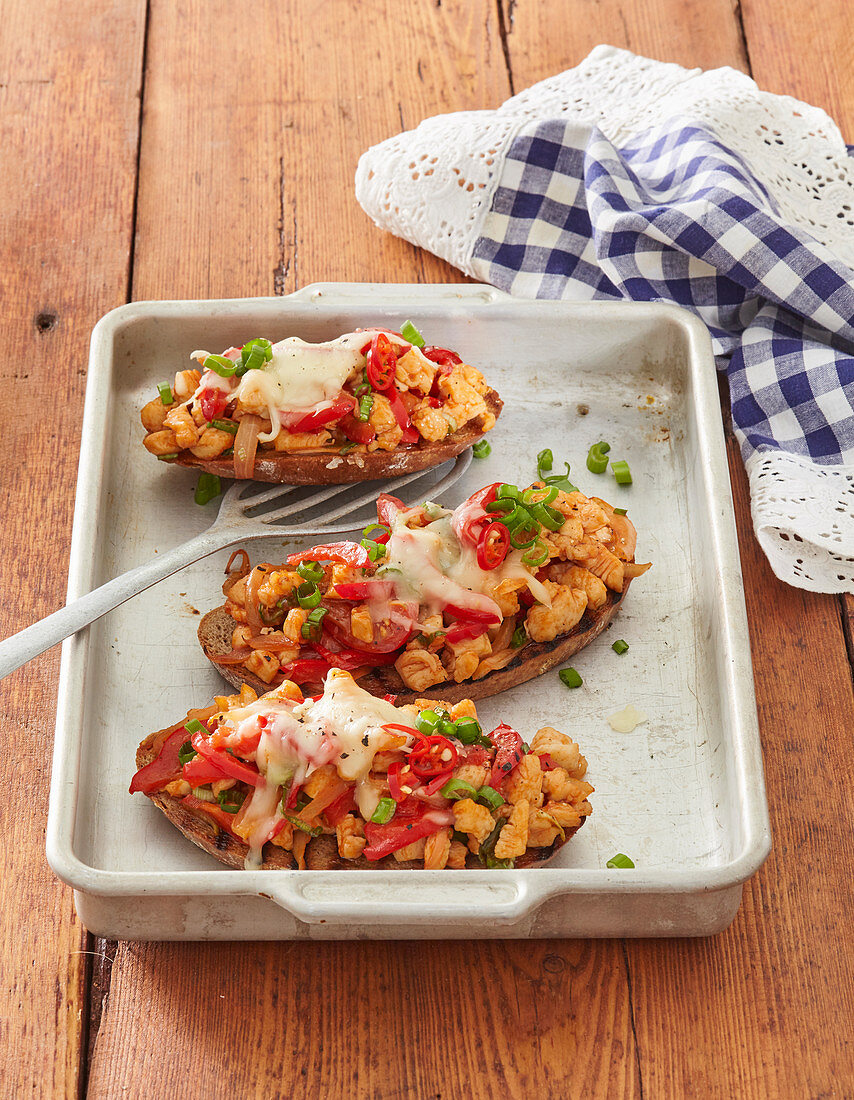 Röstbrot mit Hähnchenstreifen unter roter Paprika