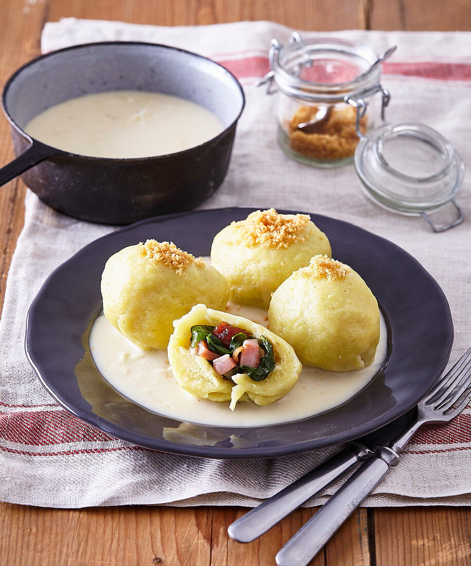 Potato dumplings with smoked meat and spinach filling and horseradish sauce