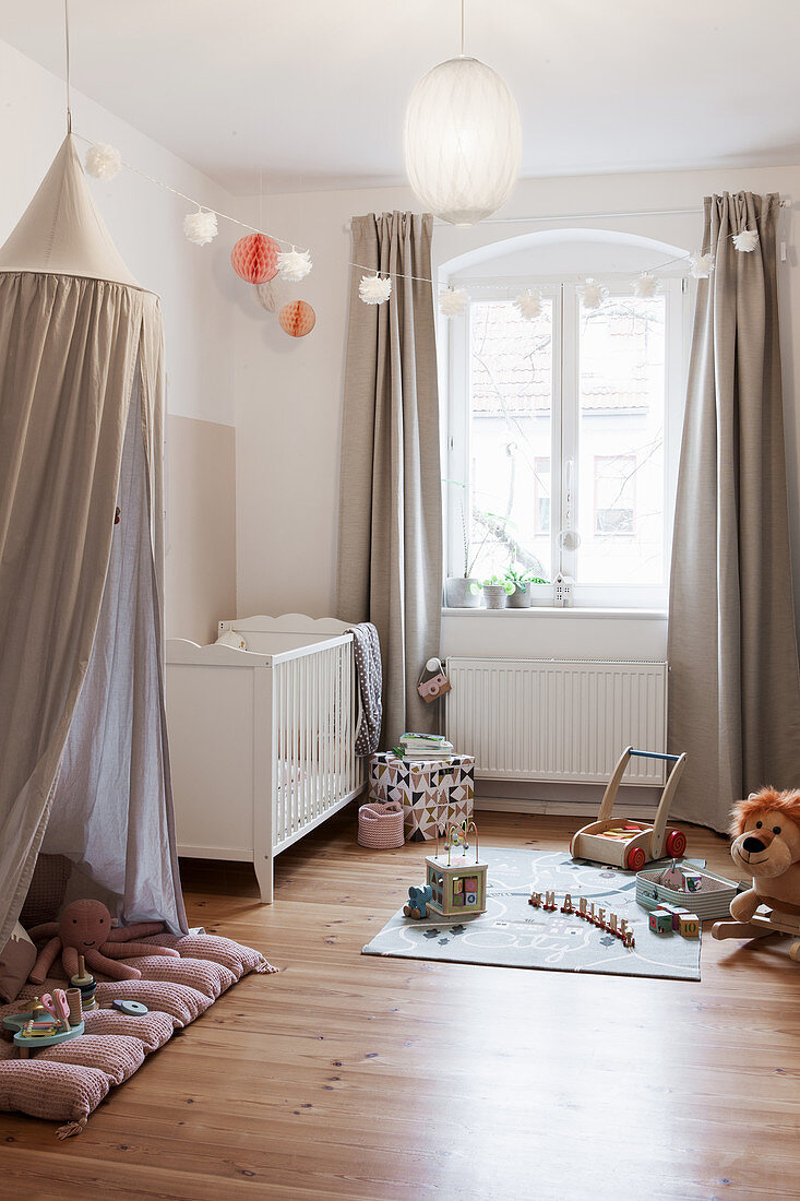 Fabric canopy, cot and play mat in nursery