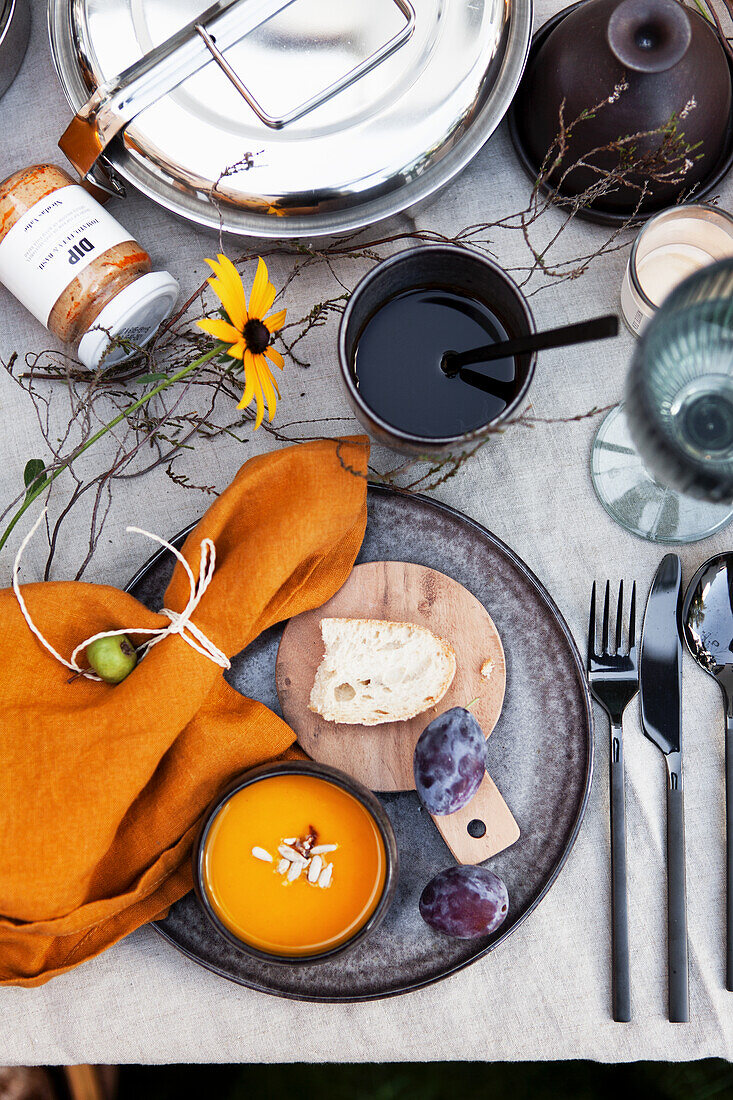 View of autumn table with pumpkin soup and plums