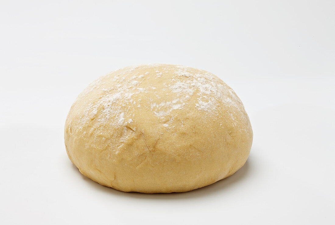 Brioche dough with flour on top on white background
