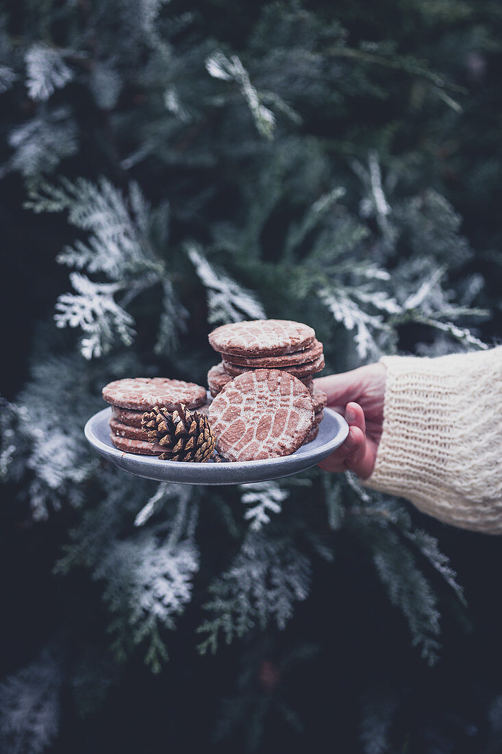 Frau hält Teller mit Lebkuchengebäck