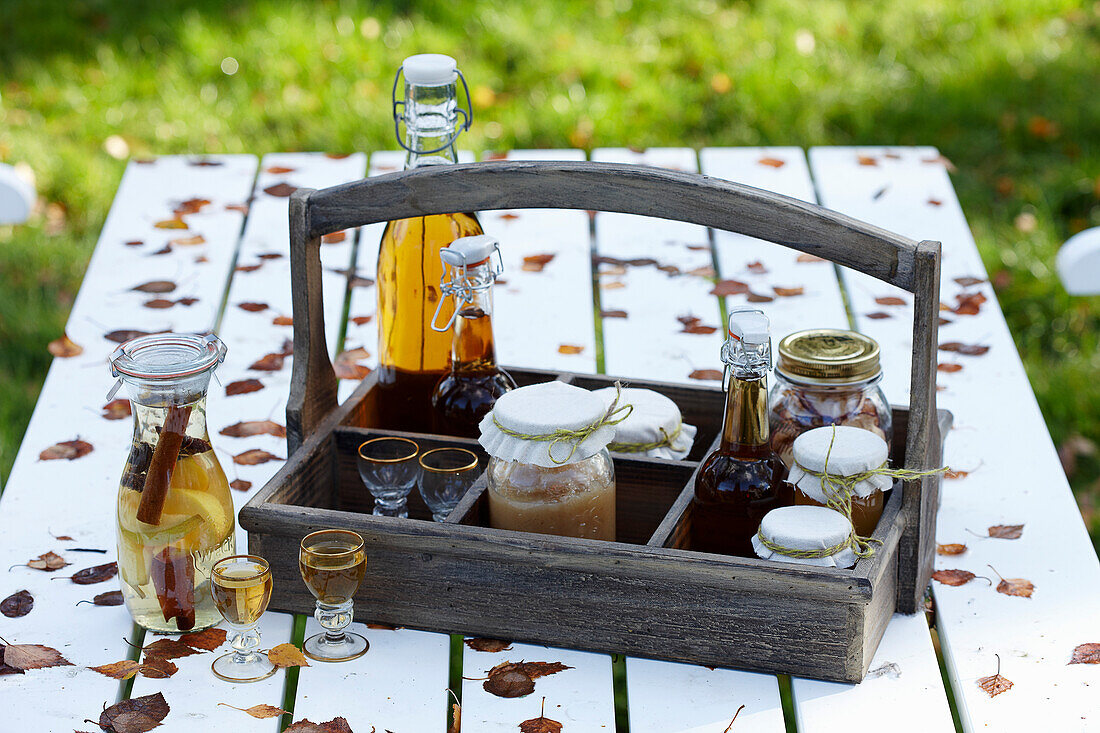 A wooden bottle carrier with apple jam, apple schnapps, apple juice and apple cider