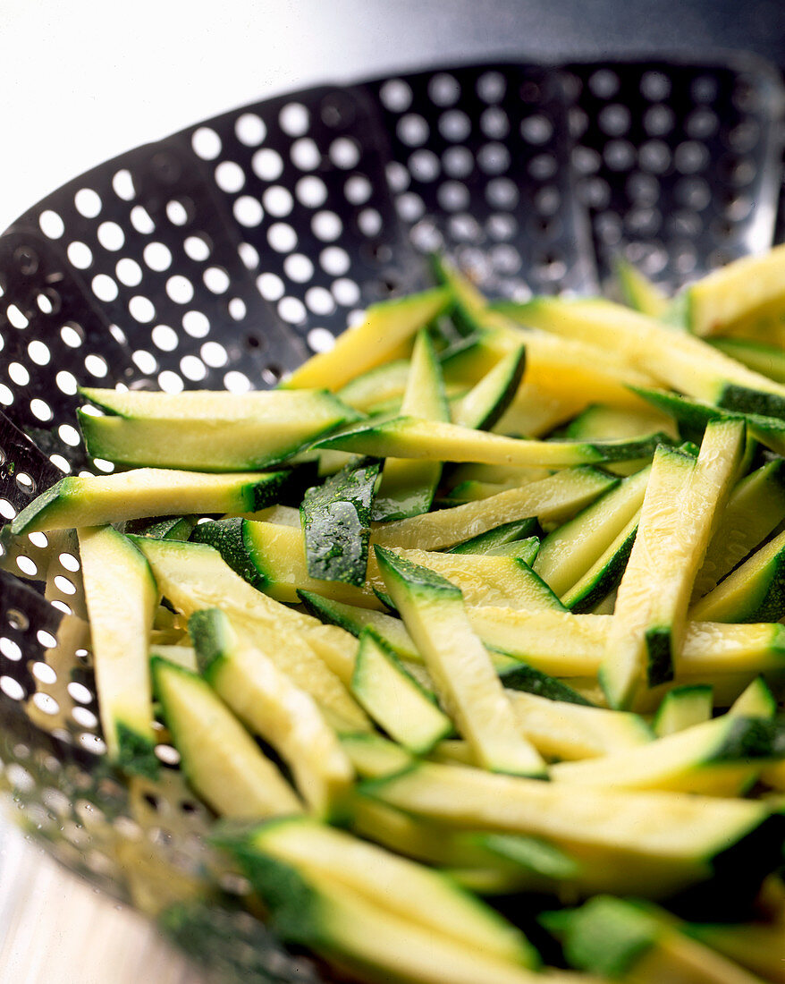 Zucchini sticks in a steamer basket