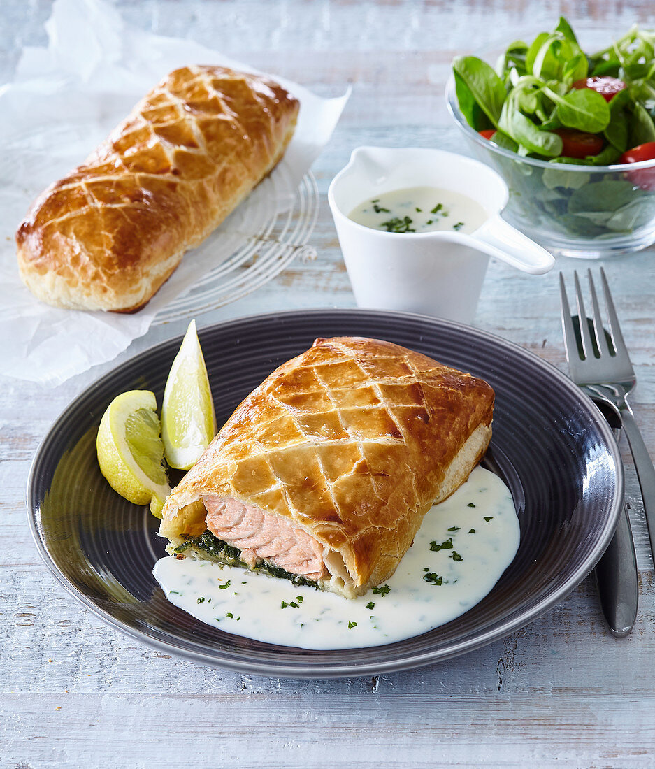 Salmon in puff pastry with spinach and herb sauce