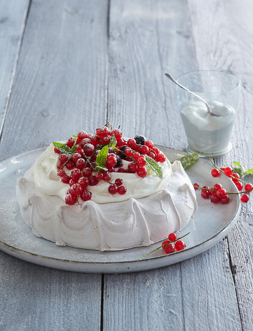 Baiserkuchen mit Schlagsahne und roten Johannisbeeren