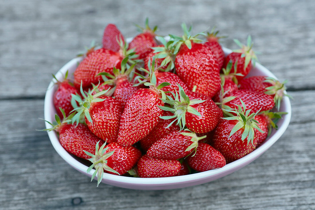 Frisch Erdbeeren in einer Schale auf Holzuntergrund