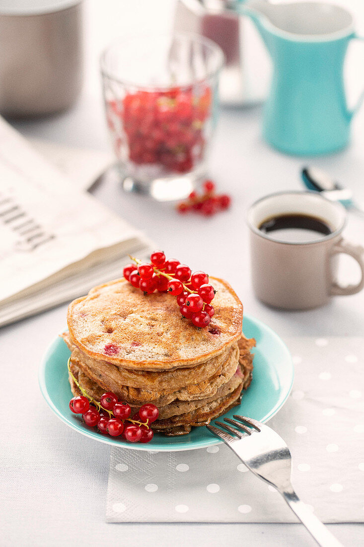 Pancakes mit Ahornsirup und roten Johannisbeeren