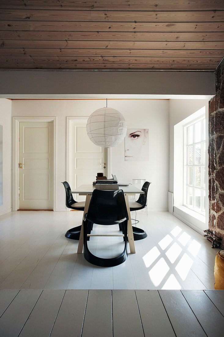 Dining table with designer chair next to lattice window