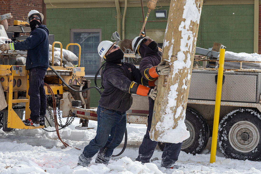 Workers putting up a utility pole