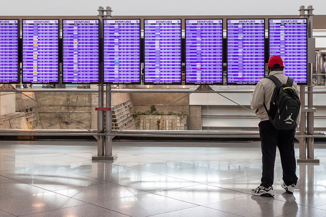 Traveller looking at airport departure boards