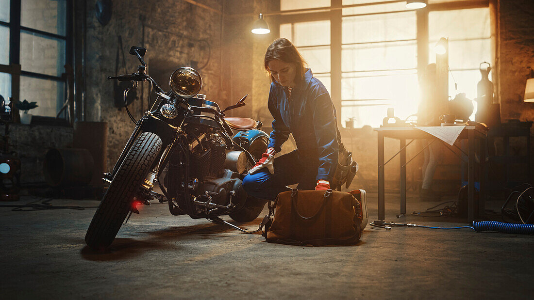 Mechanic working on a custom motorcycle in a garage