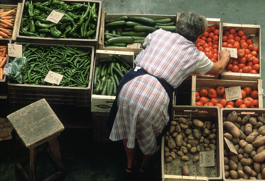 Verkäuferin über Kisten mit Gemüse auf dem Markt
