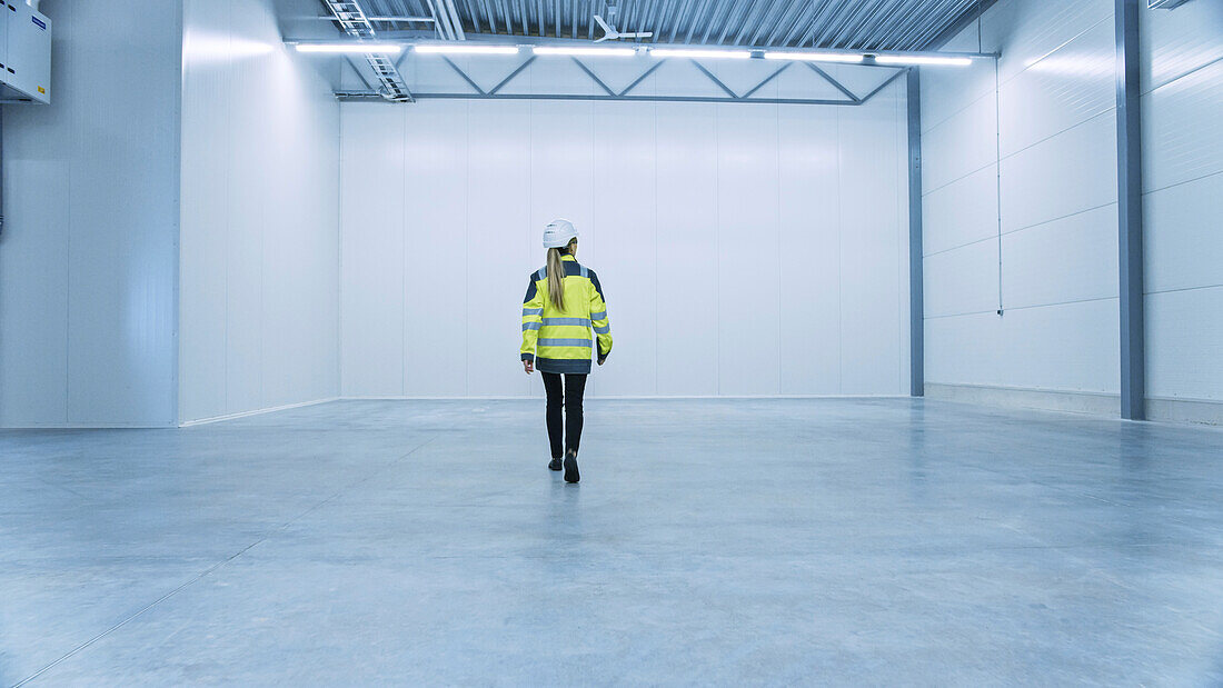 Engineer walking through an empty warehouse