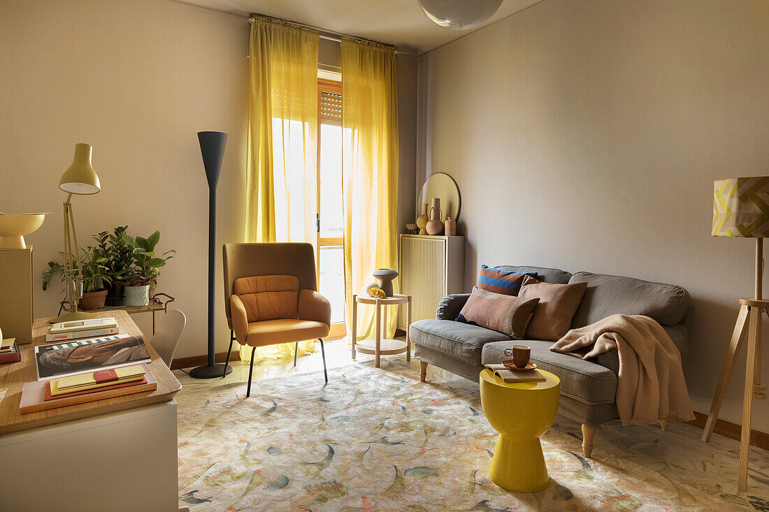 Cozy living room in yellow tones with a sofa, various lamps, and a stool