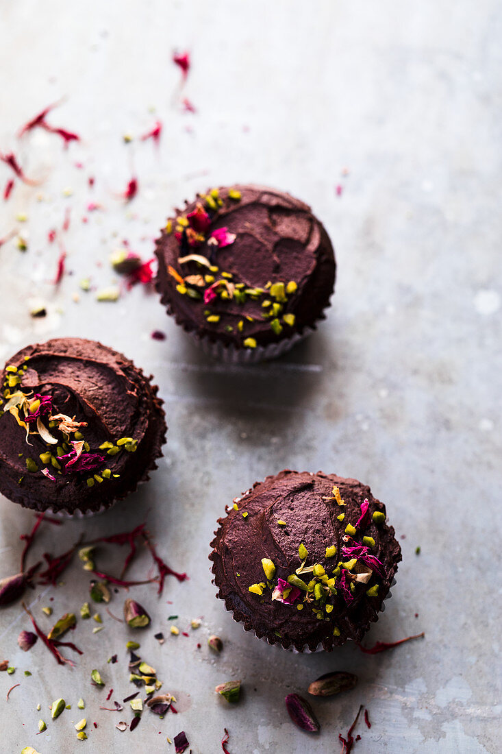 Chocolate cupcakes with edible flowers and pistachios