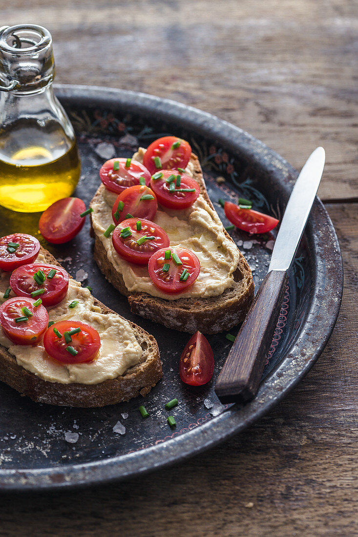 Open sandwiches with fresh hummus and cherry tomatoes