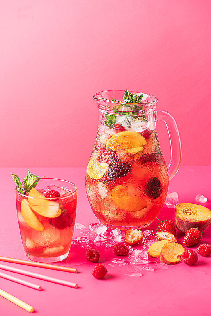 Summer fruit iced tea with peaches, raspberries, strawberries and fresh mint