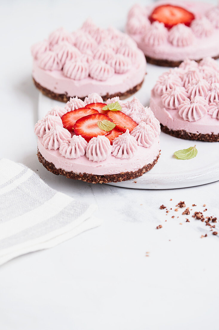 Vegan strawberry cream tartlets with almonds, cashew nuts and dates