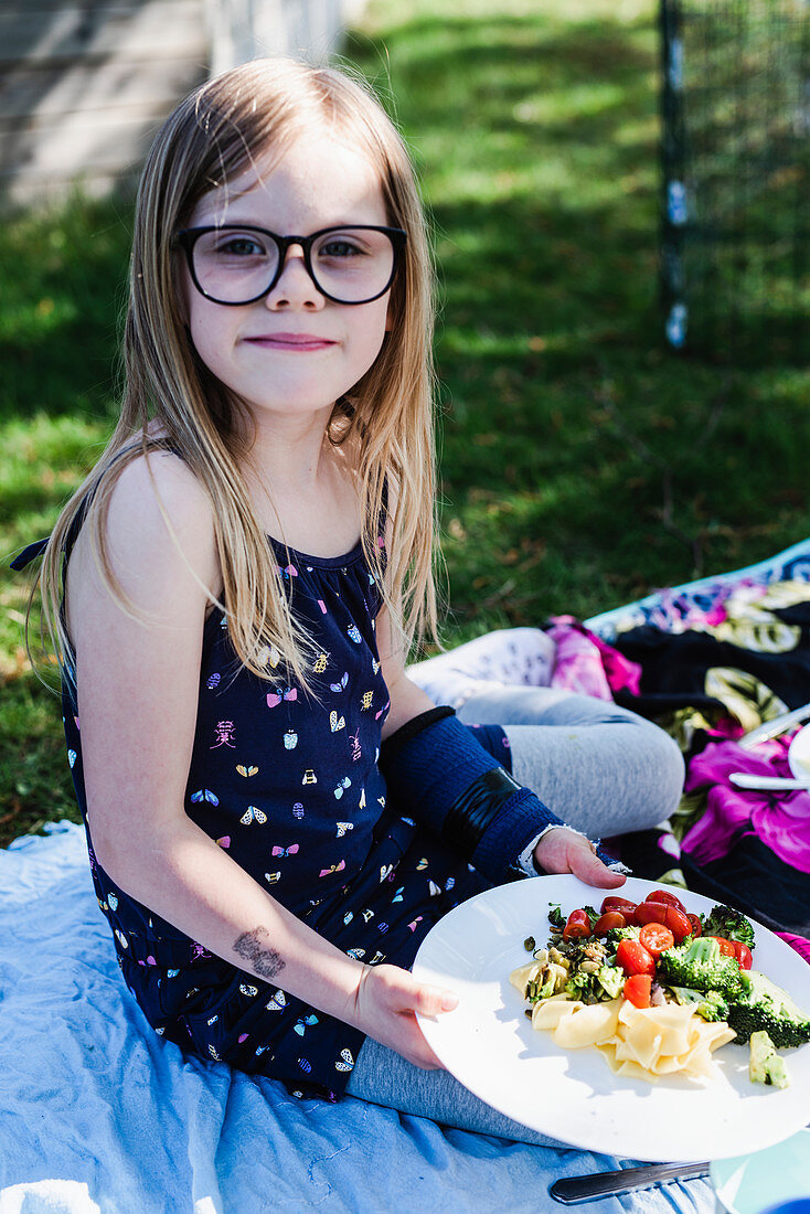 Mädchen beim Picknick mit gefülltem Teller