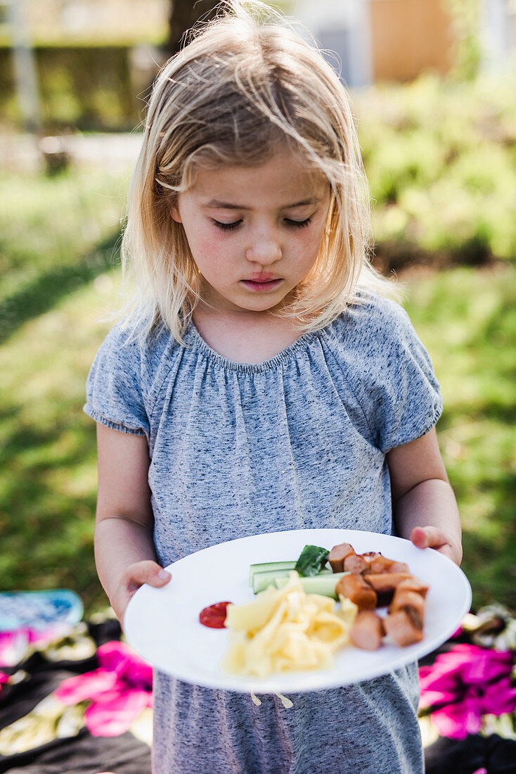 Girl looking at food on her plate