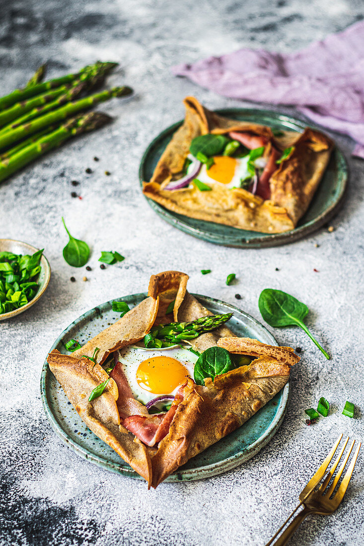 Gebackene Pfannkuchen mit Spargel, Parmaschinken, Spinat und Ei