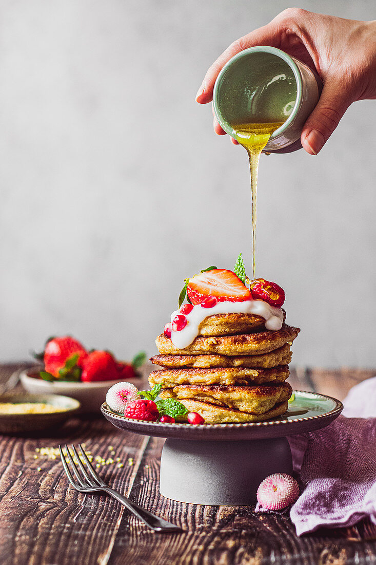 Pancakes mit Joghurt, Beeren, Granatapfelkernen und Honig